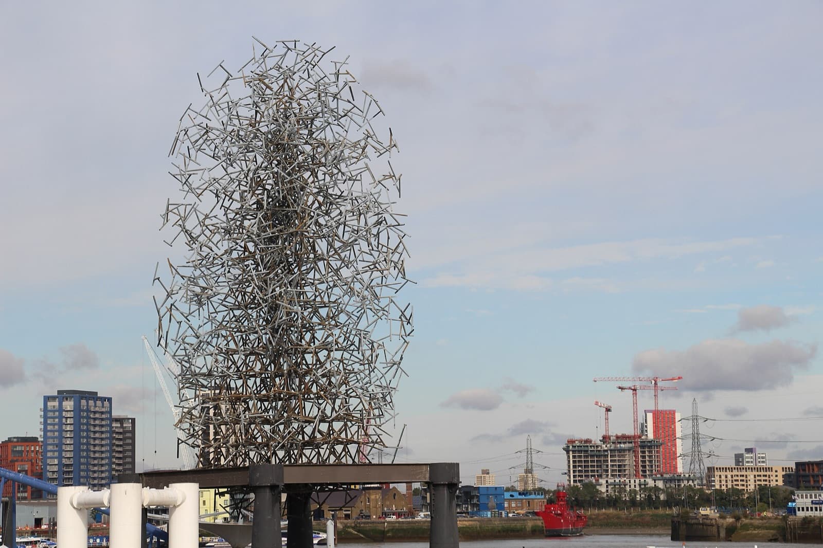 Quantum Cloud on its pier in the Thames under a stormy sky, with the cable car tower to the right